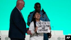 A protester holds a sign against fossil fuel during an event at the COP28 U.N. Climate Summit in Dubai, United Arab Emirates, Dec. 11, 2023.