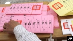 A staff sorts ballot papers at a polling station in Taipei, Taiwan, Jan. 13, 2024.