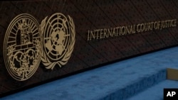 FILE - The logo of the International Court of Justice, left, and that of the U.N., right, are seen on the judges bench at the International Court of Justice, or World Court, in The Hague, Netherlands, Oct. 12, 2023. 