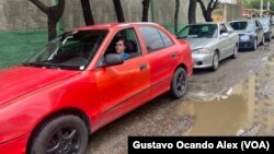 Un joven espera dentro de su vehículo para surtirse de gasolina, a las afueras de una estación de servicio, en Maracaibo, Venezuela.
