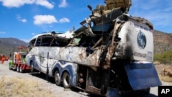 A crashed bus sits attached to a tow truck the side of the road near Villa de Tepelmeme, Oaxaca state, Mexico, Oct. 6, 2023.