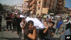 Palestinians carry bodies from the Abu Rayash family killed in Israeli shelling during their funeral in Rafah, Gaza Strip, Oct. 12, 2023. 
