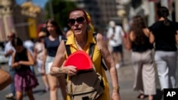 A woman fans herself in Madrid, July 10, 2023, during Spain's second heatwave of the summer.