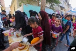 Palestinians receive food in Rafah, southern Gaza Strip, Nov. 8, 2023. Since the start of the Israel-Hamas war, Israel has limited the amount of food and water allowed to enter the territory.