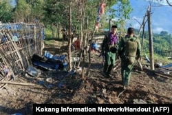 Members of the Myanmar National Democratic Alliance Army (MNDAA) walk past a Myanmar military base after seizing it during clashes near Laukkaing township in Myanmar's northern Shan state, Oct. 28, 2023.