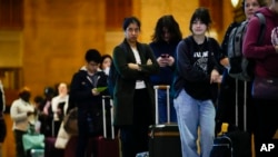 Travelers wait in line to board an Amtrak train ahead of the Thanksgiving Day holiday at 30th Street Station in Philadelphia, Nov. 22, 2023.