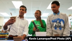 El primer ministro británico, Rishi Sunak, participa en un proyecto de sostenibilidad durante su visita a la Escuela Secundaria Preparatoria de Tecnología de la Amistad durante su viaje a Washington, el 7 de junio de 2023. (Kevin Lamarque/Pool Photo vía AP)