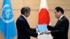Rafael Grossi, Director-General of the IAEA, left, presents IAEA's comprehensive report on the Fukushima Treated Water Release to Japanese Prime Minister Fumio Kishida, at the prime minister's office, July 4, 2023, in Tokyo.