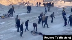 Palestinians transport casualties following what Palestinian health officials said was Israeli fire on people waiting for aid in Gaza City, in this still picture taken from a video, Feb. 29, 2024. (Reuters TV via Reuters)