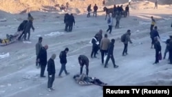 Palestinians transport casualties following what Palestinian health officials said was Israeli fire on people waiting for aid in Gaza City, in this still picture taken from a video, Feb. 29, 2024. (Reuters TV via Reuters)