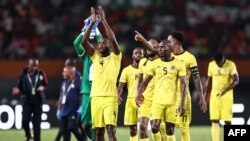 Jogadores dos Mambas cumprimentam os adeptos no final do jogo de futebol do grupo B do Campeonato Africano (CAN) 2024, entre o Egito e Moçambique, no Estádio Felix Houphouet-Boigny. (Foto de FRANCK FIFE / AFP)