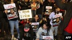 Relatives and supporters hold placards bearing portraits of Israeli hostages during a rally in Tel Aviv, Israel, calling for their release, Jan. 20, 2023. 