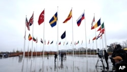 Members of the military raise the flag of Sweden on its newly installed pole during a ceremony to mark the accession of Sweden to NATO at NATO headquarters in Brussels, March 11, 2024.
