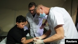 A Palestinian boy sits on a bed as he receives treatment at the hospital onboard the French ship amphibious helicopter carrier Dixmude as it docks in the city of Al-Arish, Sinai peninsula, Egypt, Jan. 21, 2024.