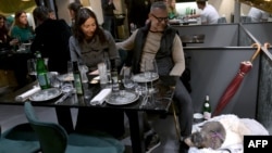 Customers look at their dog at the Fiuto restaurant in Rome on Nov. 21, 2023.