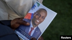 ARCHIVO - Una persona sostiene una fotografía del fallecido presidente haitiano Jovenel Moïse en la casa de su familia en Cabo Haitiano, Haití, el 23 de julio de 2021. Moïse fue asesinado ese mes en su residencia de Puerto Príncipe.