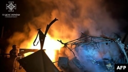 This handout picture by Ukrainian Emergency Service shows a firefighter pushing out a fire in destroyed private house following Russian strike in Kupiansk, Nov. 9, 2023. (Photo by Handout / Ukraine Emergency Service / AFP) 
