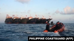 菲律賓海岸警衛隊發布照片顯示其巡邏艇駛過停泊在南中國海牛軛礁附近的多艘中國船隻。 （2021年4月14日）