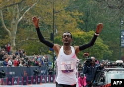 Ethiopia's Tamirat Tola celebrates winning the 52nd Edition of the New York City Marathon, Nov. 5, 2023.