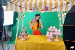 In this photo released by Oreo Deng, Oreo Deng, a former English tutor who sells jewelry to US customers by livestreaming on TikTok, poses for a photo in her studio in Shenzhen in southern China's Guangdong province in June 2023.