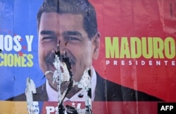 A burned election billboard of Venezuelan President Nicolas Maduro is seen in Caracas on July 31, 2024.
