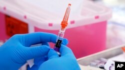 FILE - A flu vaccine is readied at the LA Care and Blue Shield of California Promise Health Plans' Community Resource Center in Lynwood, Calif., on Oct. 28, 2022. 