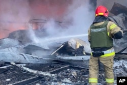 A firefighter works to extinguish a blaze after a Russian missile attack in Kryvyi Rih, Ukraine, Jan. 8, 2024. (Ukrainian Emergency Service via AP)