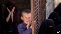 FILE - Children stand in al-Hol camp, which houses families of members of the Islamic State group in Hasakeh province, Syria, April 19, 2023.