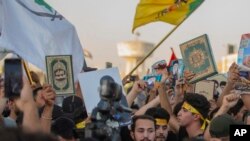 Para pengunjuk rasa Irak mengacungkan Al-Qur'an dalam demonstrasi di Lapangan Tahrir, Baghdad, Irak, Kamis, 20 Juli 2023. (Foto: (AP Photo/Adil AL-Khazali)