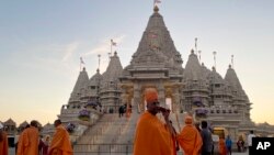 Monks walk in front of the BAPS Swaminarayan Akshardham, the largest Hindu temple outside India in the modern era, on Oct. 4, 2023, in Robbinsville, N.J. (AP Photo/Luis Andres Henao)