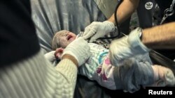 A Palestinian infant wounded in an Israeli strike on a house receives medical attention, after a temporary truce between Hamas and Israel expired, at Nasser hospital in Khan Younis in the southern Gaza Strip, Dec. 1, 2023.