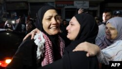 Rawda Abu Ajamieh, left, hugs a relative after her release from an Israeli prison as part of a truce agreement between Israel and Hamas, in the al-Duheishe refugee camp in Bethlehem's occupied West Bank, Nov. 24, 2023.