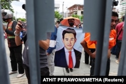 Seorang pendukung Pemimpin Partai Maju Maju memegang lukisan Pita Limjaroenrat pada hari pemungutan suara kedua untuk perdana menteri baru, di parlemen di Bangkok, Thailand, 19 Juli 2023. (Foto: REUTERS/Athit Perawongmetha)