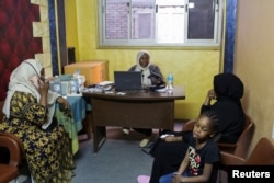 Amal Rahal, head of Amal al-Mostaqbal "Hope for Future" initiative, checks and records documents and passports of Sudanese displaced women in the capital city of Cairo, Egypt, May 13, 2023.