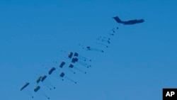 An aircraft airdrops humanitarian aid over the northern Gaza Strip, as seen from southern Israel, March 10, 2024.
