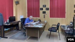 FILE - Marion County Record owner Eric Meyer edits an article in his office on Aug. 21. Meyer said that the suspension and resignation of the police chief who raided his office and home came too late. (Liam Scott/VOA)