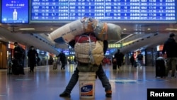 资料照：北京火车站里一名携带个人财产的旅客。（2021年1月13日）