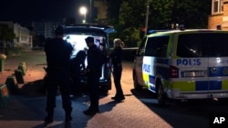 Police stand on the scene after a man was shot dead and another person was injured in Jordbro, south of Stockholm, in the early hours of Sept. 28, 2023. 