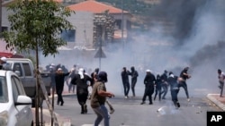 Druze protesters clash with Israeli police who fired tear gas as thousands took part in a demonstrations against the construction of massive wind turbines, in the Golan Heights, June 21, 2023. 