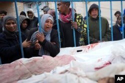 Palestinians mourn relatives killed in an Israeli air and ground offensive on the Gaza Strip at a hospital in Deir al Balah, Jan. 26, 2024.