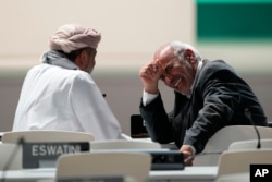 A delegate from Bolivia, right, laughs ahead of a stocktaking plenary session at the COP28 U.N. Climate Summit in Dubai, United Arab Emirates, Dec. 9, 2023.