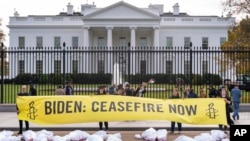 A large banner that says "Biden: Ceasefire Now" along with fake white body bags, representing those killed in the escalating conflict in Gaza and Israel, is displayed in front of the White House, Nov. 15, 2023.