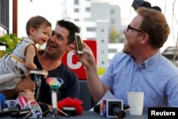 FILE - U.S. citizen Gordon Lake (R), his Spanish husband Manuel Santos and their baby Carmen attend a news conference after they won an appeal for parental rights over a baby born through a Thai mother, in Bangkok, Thailand, April 29, 2016.