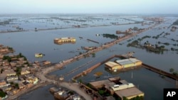 FILE - Homes are surrounded by floodwaters in Sohbat Pur city, a district of Pakistan's southwestern Baluchistan province, Aug. 29, 2022.