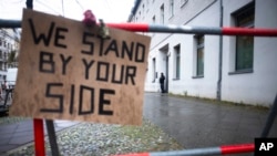 FILE - A police officer guards the entrance of the building complex of the Kahal Adass Jisroel community, which houses a synagogue, a kindergarten and a community center, in the center of Berlin, Germany, Nov. 8, 2023.