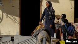 A Palestinian woman and a child look at the site of an Israeli air strike in the Gaza Strip, March 9, 2024. U.S. President Joe Biden said Israeli Prime Minister Benjamin Netanyahu is "hurting Israel more than helping" in how he is approaching its war against Hamas in Gaza.