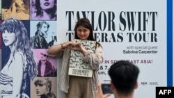 អ្នកគាំទ្រតារាចម្រៀងអាមេរិកនាង Taylor Swift ថតរូប​នៅពេល​ចូលរួម​ទស្សនា​ការប្រគុំតន្ត្រី Eras Tour នៅពហុកឡដ្ឋានជាតិ​នៅទីក្រុងសិង្ហបុរី កាលពីថ្ងៃទី៧ ខែមីនា ឆ្នាំ២០២៤។