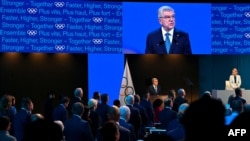 International Olympic Committee (IOC) President Thomas Bach (C, right) addresses delegates on the first day of the 141st IOC Session in Mumbai, India, Oct. 15, 2023.