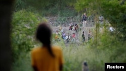 Venezuelan asylum seeker Nathaly, 13, observes a group of migrants being turned back to Mexico by U.S. border patrol agents, while she and her family wait to attempt to cross into the U.S., at a makeshift camp, in Matamoros, Mexico June 21, 2023.