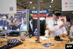 FILE - Startups demonstrate their technology during the Collision conference in Toronto, Ontario, June 28, 2023.